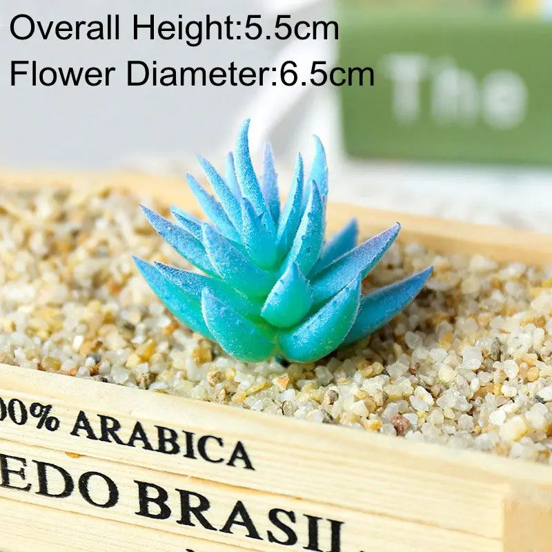 A bright blue artificial succulent plant with a flower diameter of 6.5 cm is displayed on a wooden tray filled with sand.
