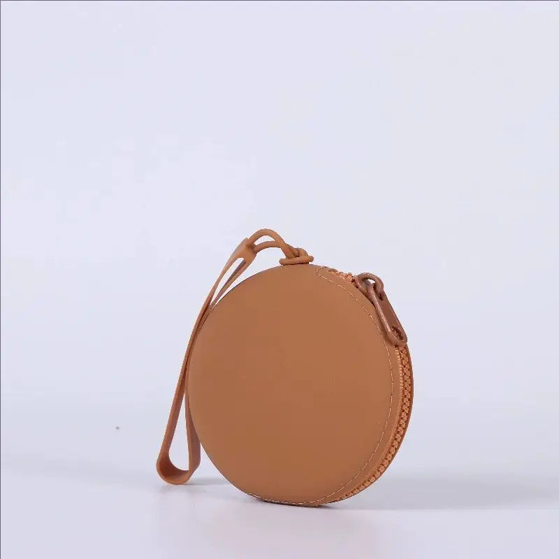 A round, tan silicone pet treat pouch with a loop closure is shown against a white background.
