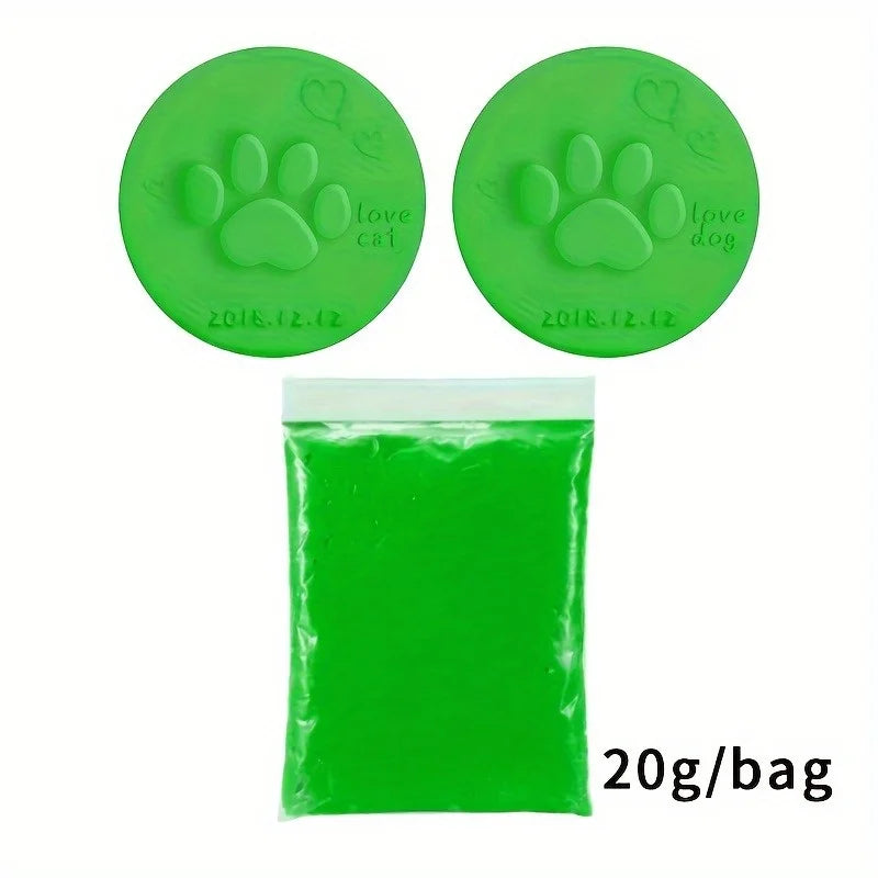 A green clay kit with paw print molds and a bag of green clay for making pet memory ornaments.