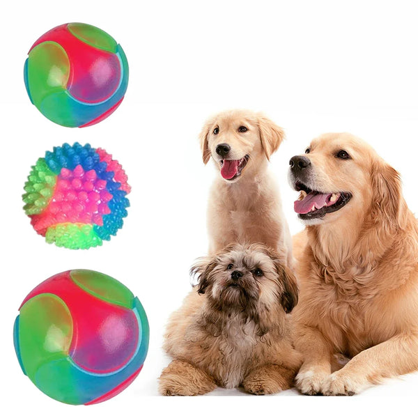 A golden retriever and a poodle sitting next to three glowing rubber fetch balls: green, pink, and blue.