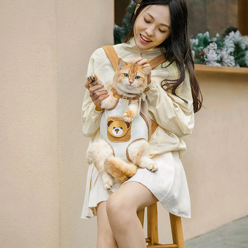 A young woman is holding a fluffy orange tabby cat in a breathable mesh carrier backpack while sitting down.