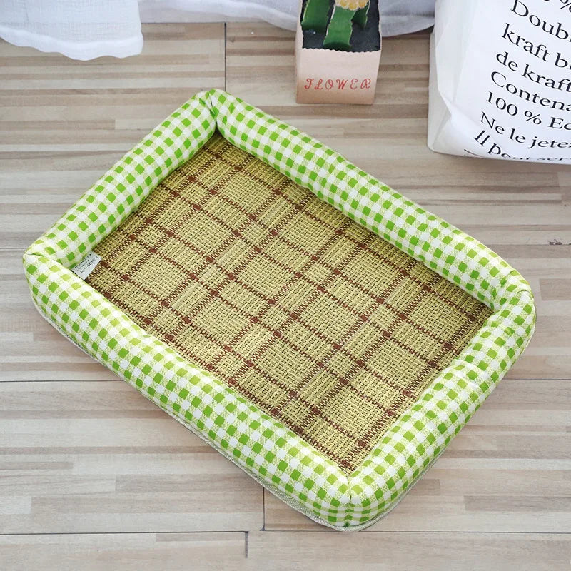 A rectangular pet bed with a green and white fabric border and a natural woven mat is shown on a wooden floor.