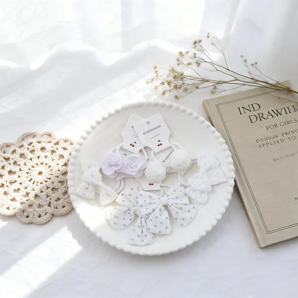 Nœuds élastiques blancs et accessoires présentés sur une assiette à côté d'un livre.