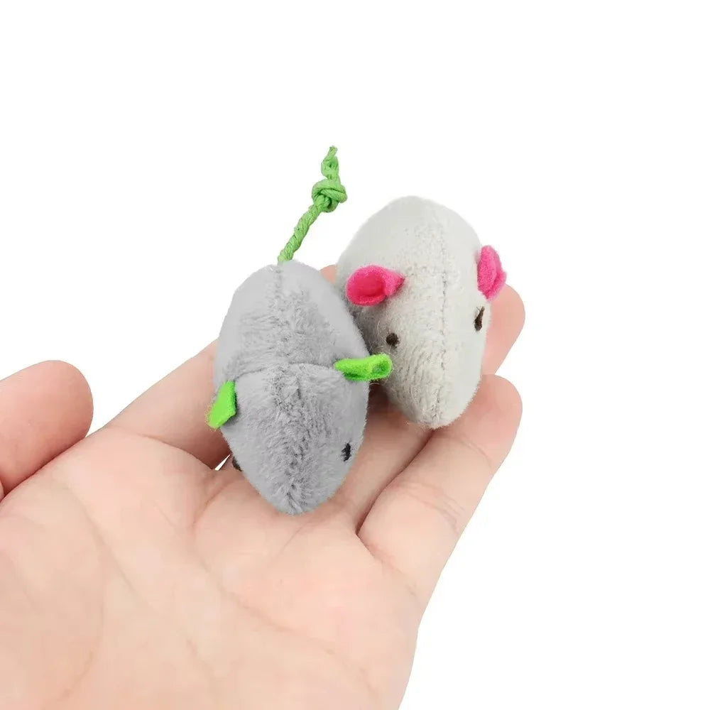 A hand holds a plush cat mouse toy with a green string and pink details.
