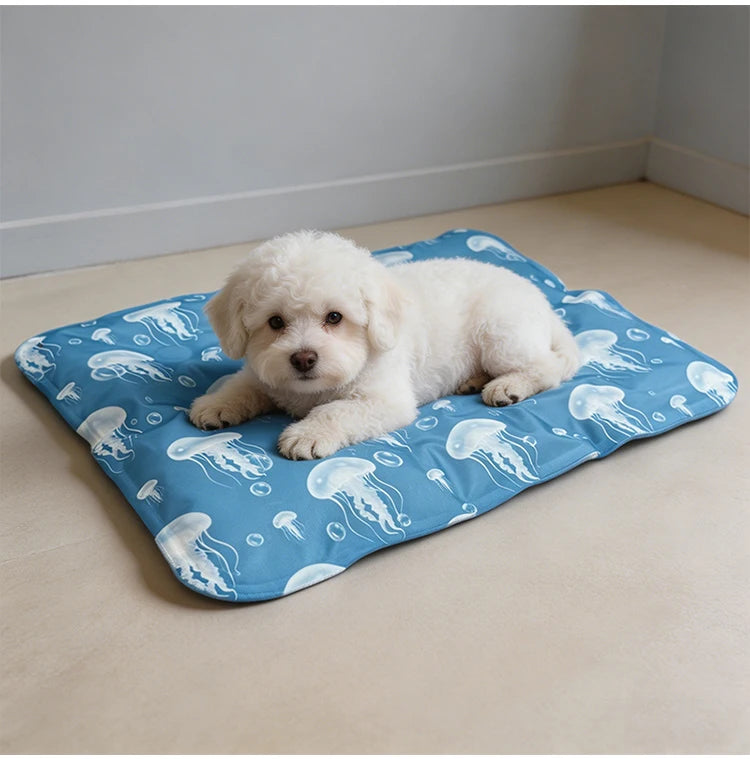 Ein flauschiges weißes Welpe liegt auf einer blauen Hundekühlmatte mit weißen Quallenmustern.