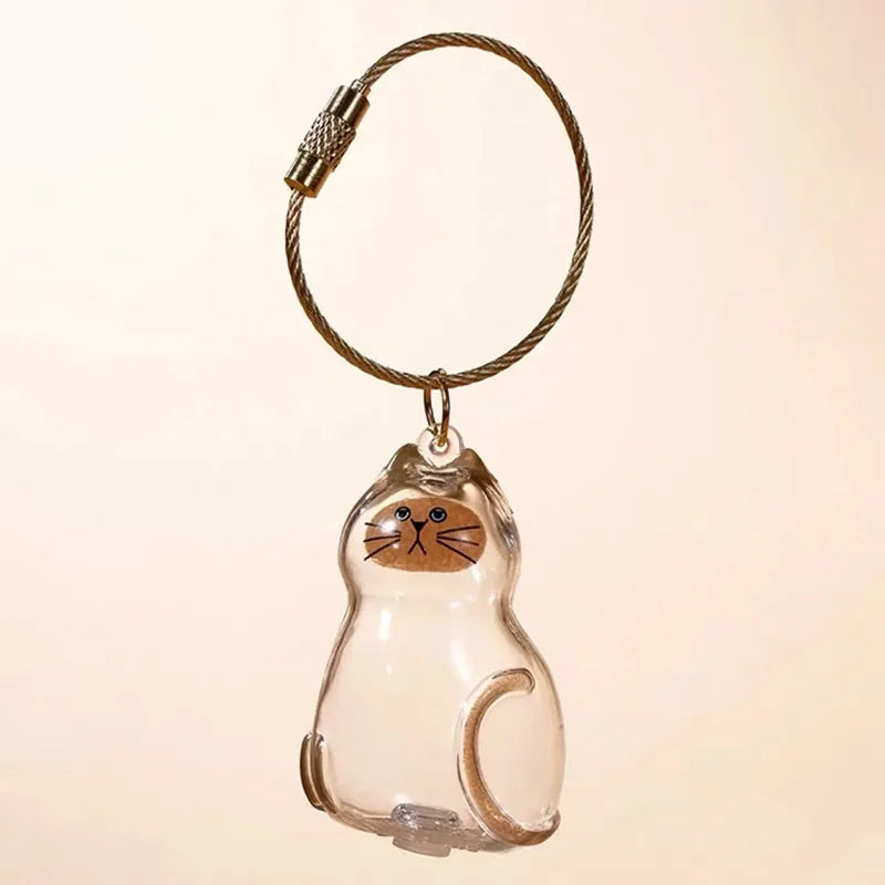 Klares Glaskatzen-Anhänger-Schlüsselanhänger mit goldfarbener Lederleine und kleinem Metallverschluss.