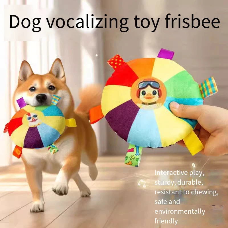 A hand holds a colorful frisbee dog toy while a happy dog is nearby.