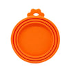 Orange reusable silicone pet food can lid with a spoon.