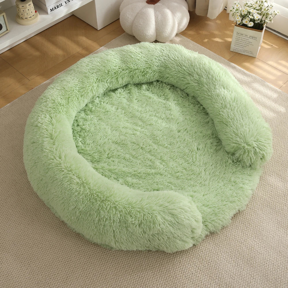 A round, light green faux fur dog bed resting on a beige rug.