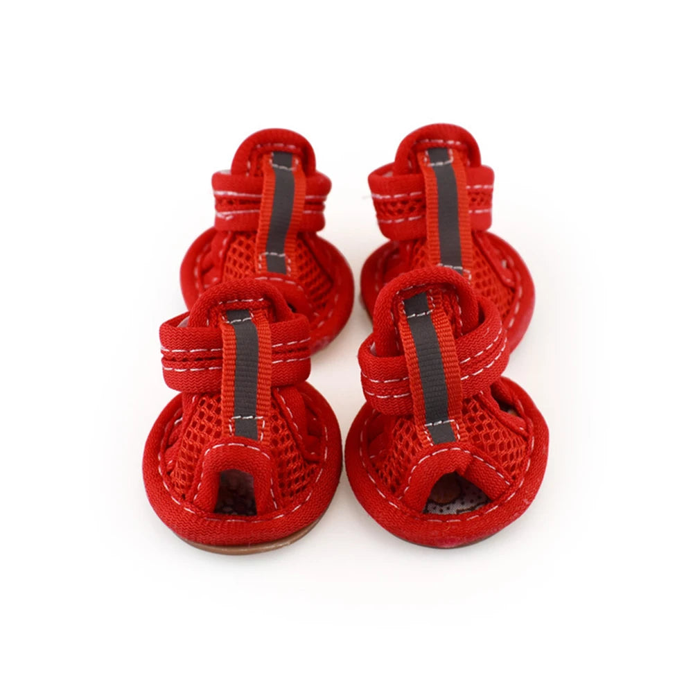 A pair of red breathable summer dog shoes with black accents shown from above.
