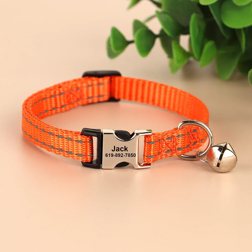 Orange reflective nylon cat collar with a silver bell and an ID tag attached.