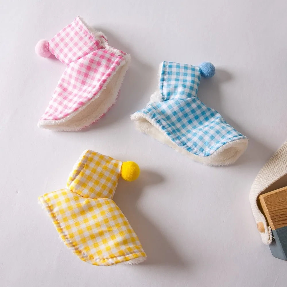 A set of plaid fabric parrot cape and hat featuring pink, blue, and yellow checkered patterns.