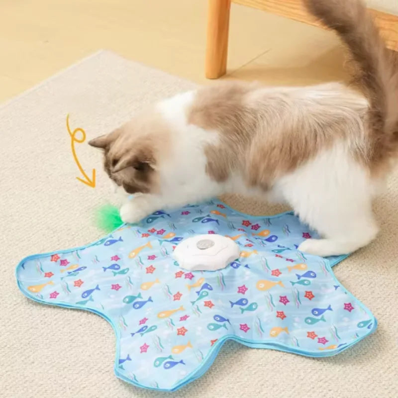 A fluffy tabby cat is playing with a blue squeaky mouse toy on a light-colored mat.