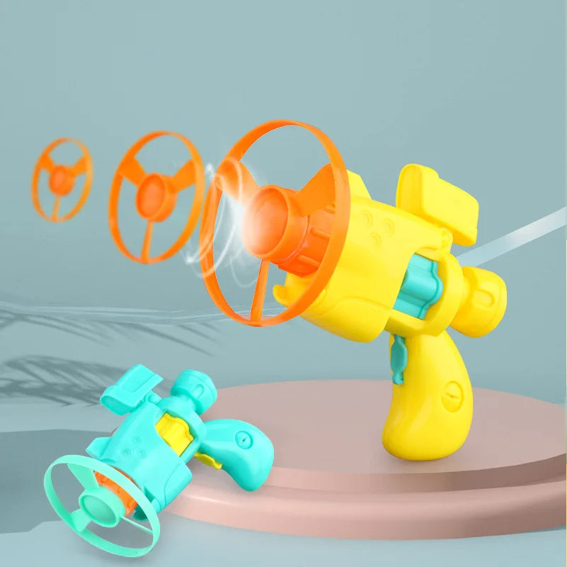A yellow toy launcher set with four orange discs, including a separate blue disc.