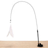 A long black feather wand toy with a suction cup and white feathers is shown against a wooden surface.