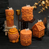 Several orange honeycomb silicone molds for candles and crafts are displayed on a dark wooden surface.