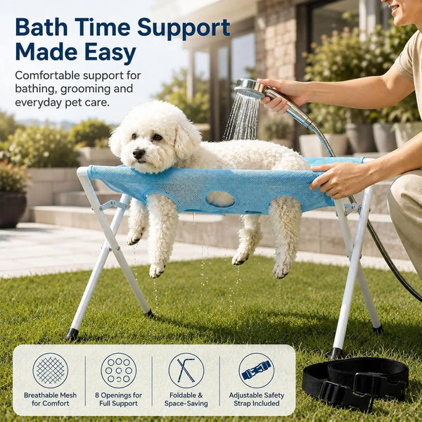 A person is using a blue foldable pet grooming hammock for bath time support on a lawn.
