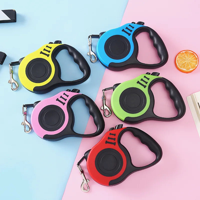 Five colorful automatic retractable dog leashes are displayed on a pink and blue background.