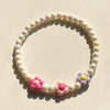 A circular necklace set made of pastel floral beads, featuring pink and purple flowers.