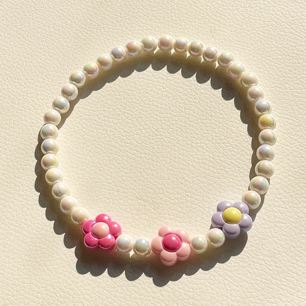 A circular necklace set made of pastel floral beads, featuring pink and purple flowers.