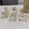 Un ensemble de figurines d'animaux en verre transparent, en forme de chats, avec une corde dorée pour porte-clés.