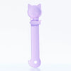 Cuchara dispensadora de comida para gatos con diseño de cabeza de gato y mango largo de color lila claro.