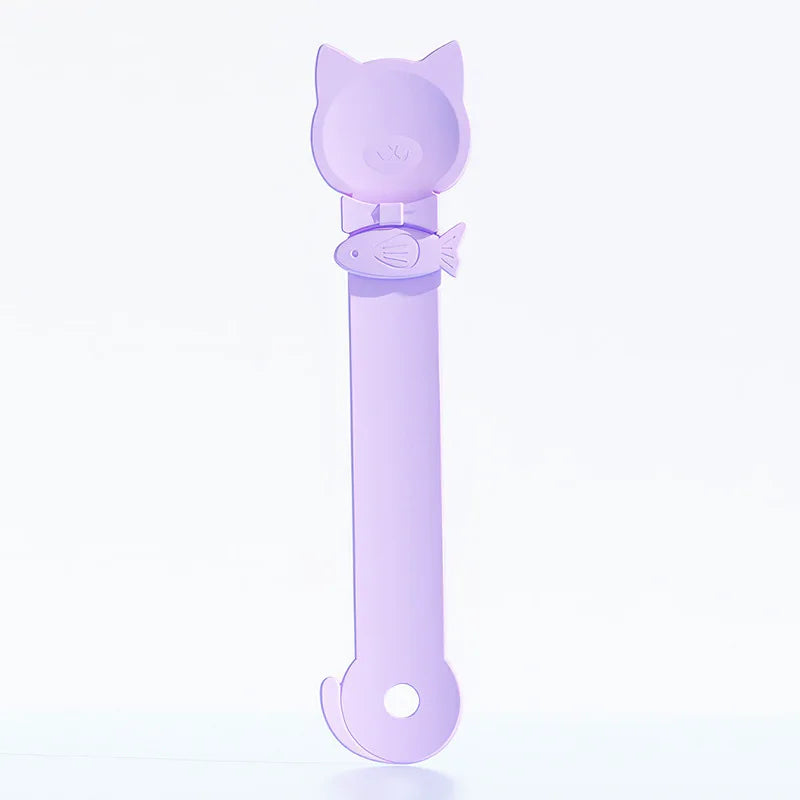 Cuchara dispensadora de comida para gatos con diseño de cabeza de gato y mango largo de color lila claro.