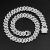 A close-up of a silver iced out Cuban link chain necklace with rhombus diamond accents lying on a black background.