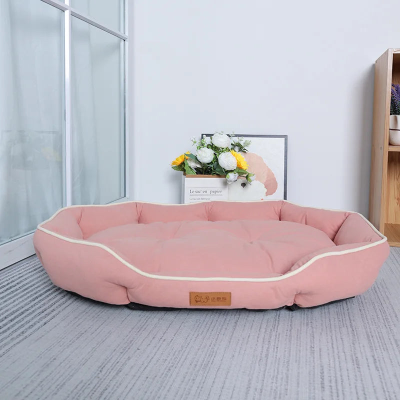 A pink luxurious corduroy pet sofa bed for dogs and cats resting on a light gray floor.