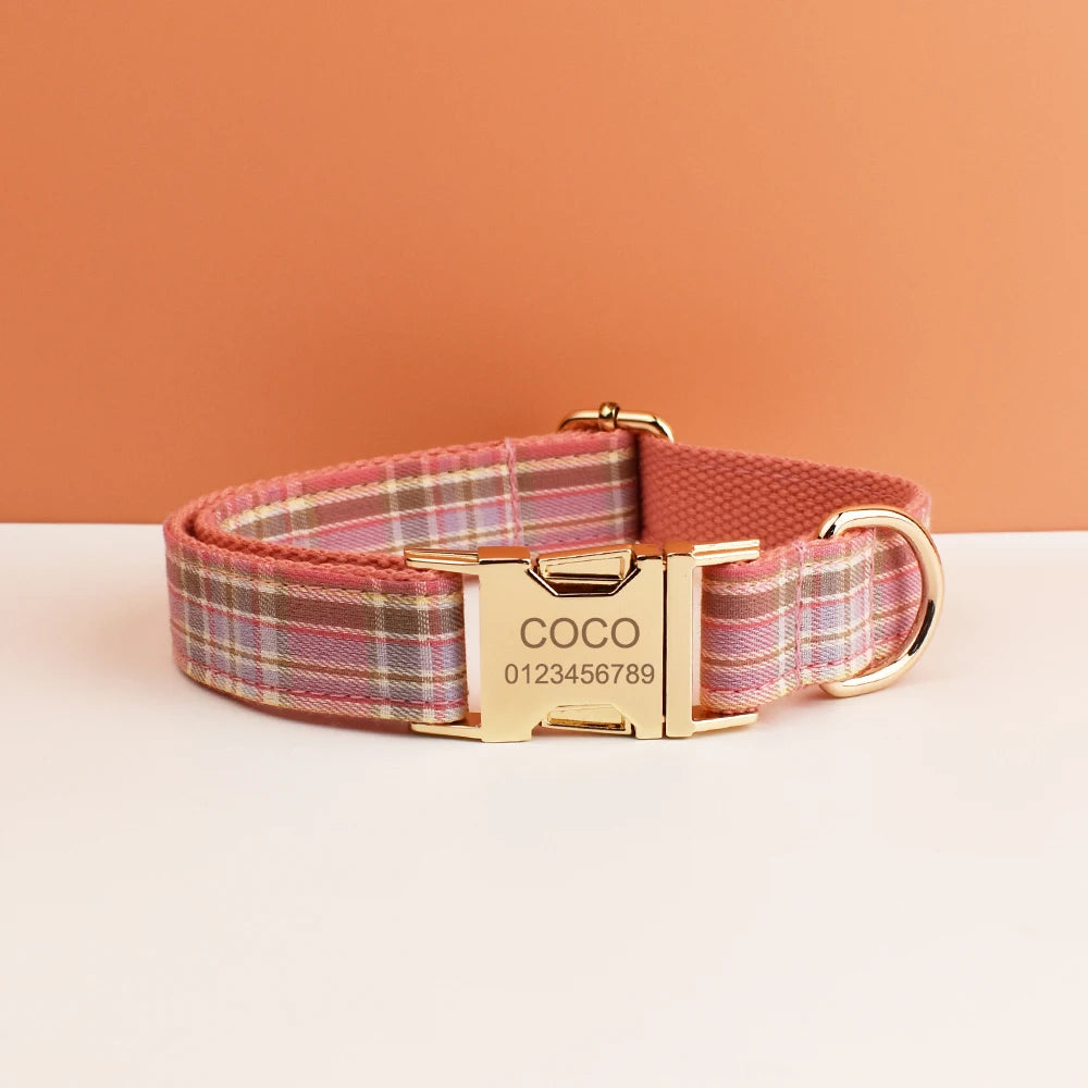 A pink plaid dog collar with a gold buckle and the name COCO engraved on the tag.