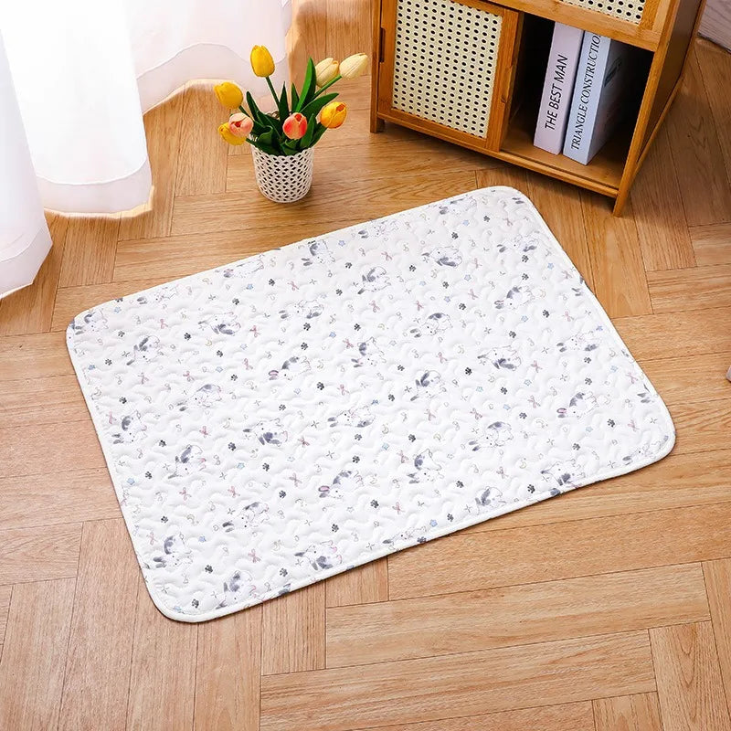 A white soft cotton pet cage mat with a non-slip base placed on a wooden floor next to a potted yellow tulips.