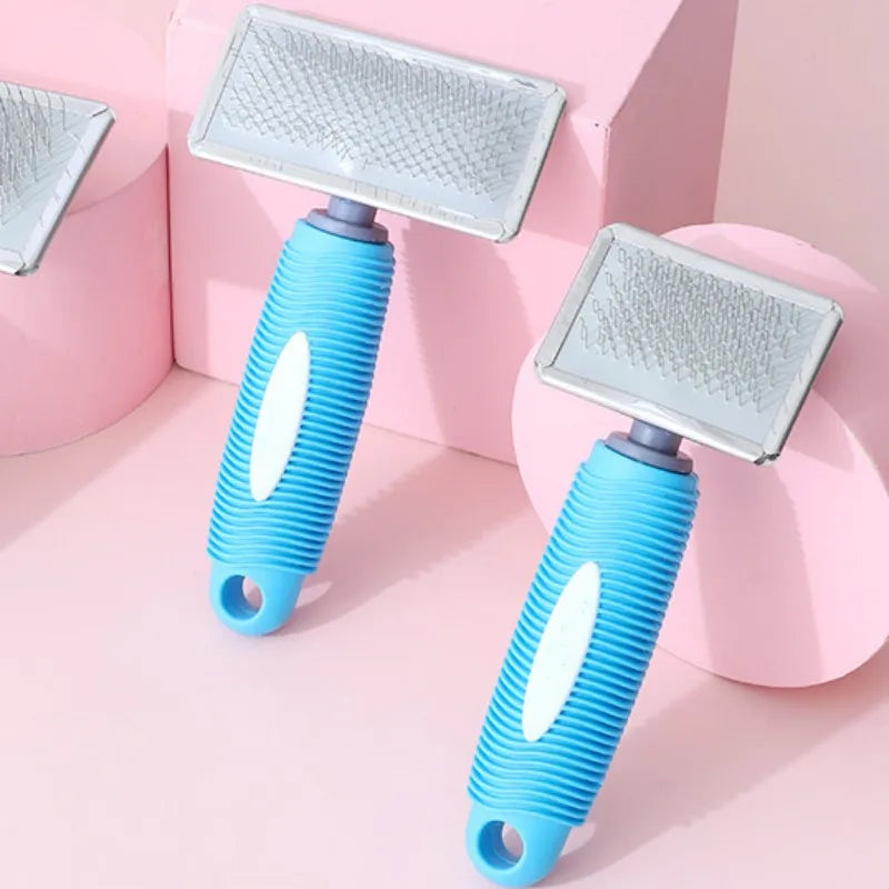 A pair of blue silicone pet combs with stainless steel pins are displayed on a pink background.