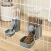 A grey automatic pet feeder waterer for dogs and cats is shown inside a wire cage.