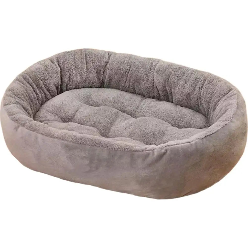 A plush, oval pet bed with a raised rim in a soft gray color.