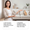 A woman is presenting a pet deterrent spray for furniture and carpets next to a cat on a sofa.