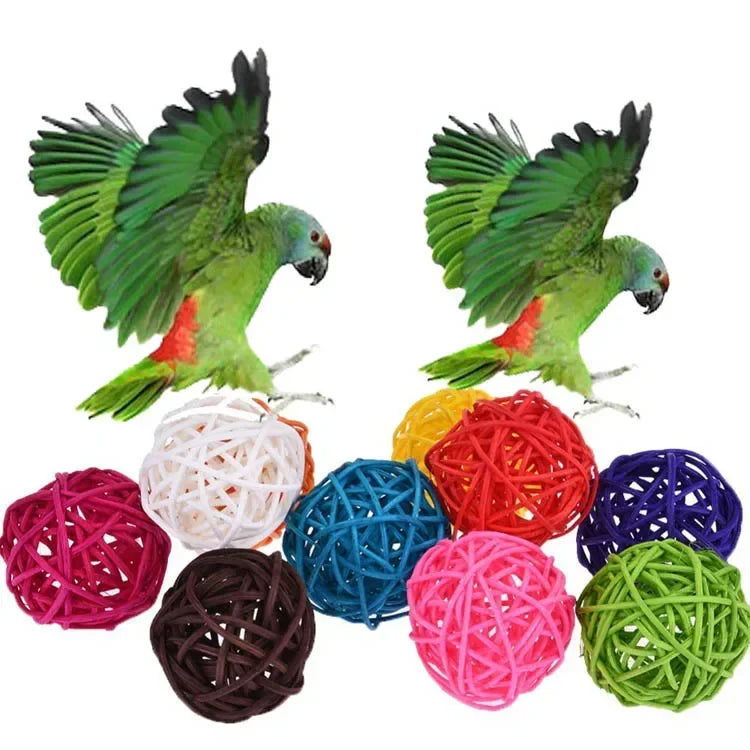 A collection of natural rattan chewing balls in various colors including green, red, purple, and black.