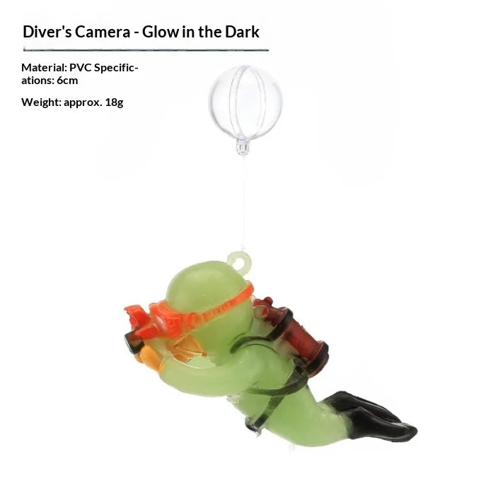 A clear, spherical diving ornament with an orange and green plastic body suspended by a thin string.