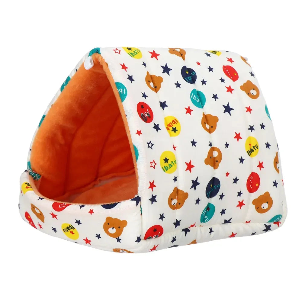 A white quilted pet nest bed with an orange interior and colorful star and fruit patterns.