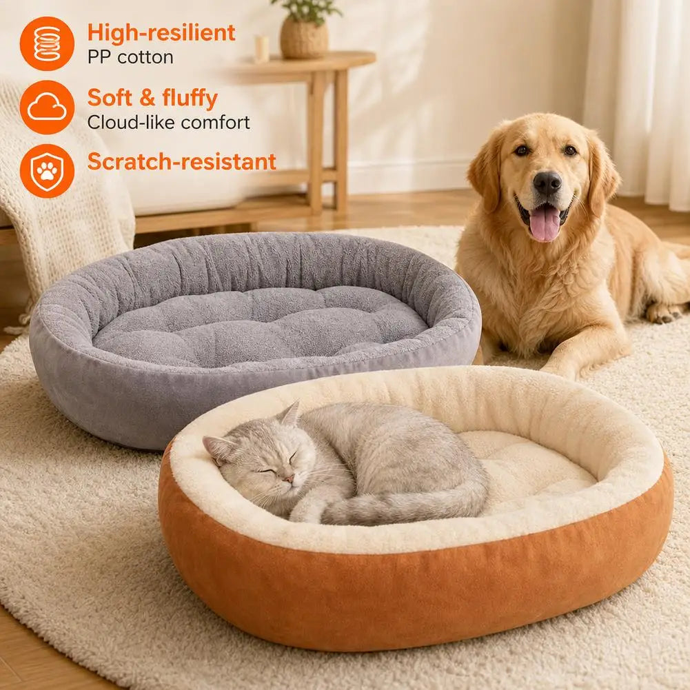 A plush oval pet bed with a raised rim in beige and orange fabric resting on a light-colored rug.