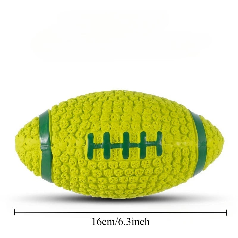 A bright yellow squeaky latex ball for dogs with green stitching, shown from the side.