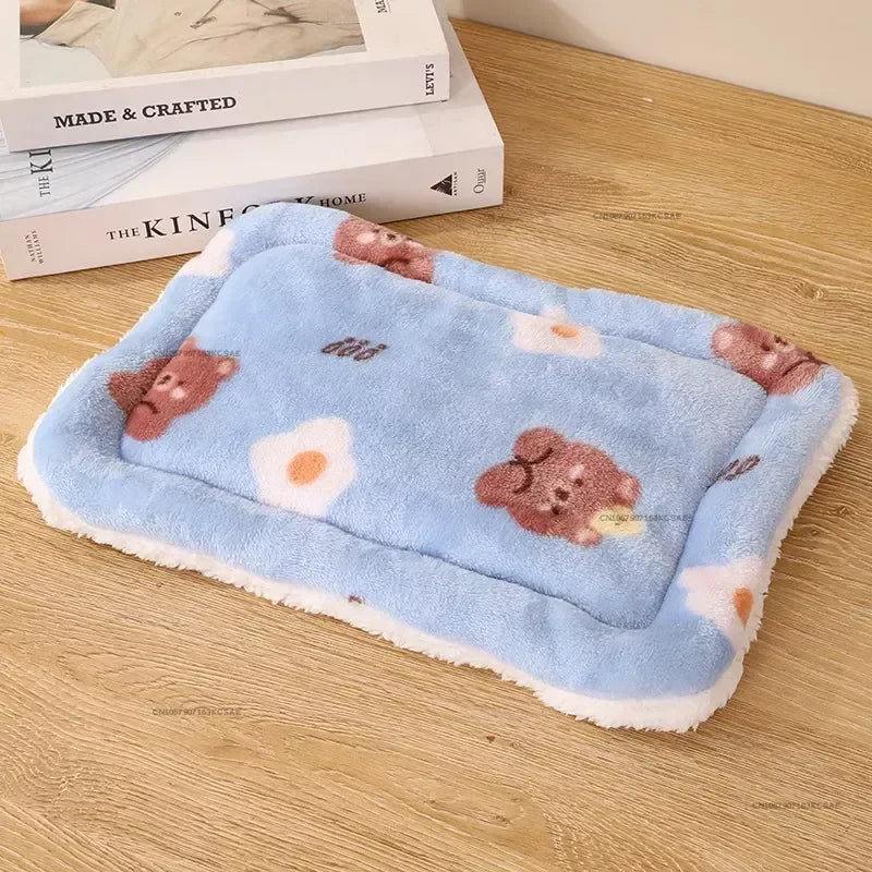 A light blue fleece pet bed mat featuring cute brown animal paw prints and white egg shapes.
