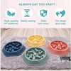 A set of three silicone slow feeder dog bowls in blue, green, and pink resting on a gray mat.