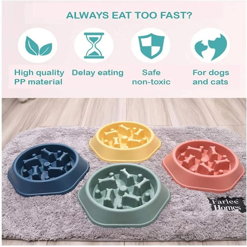 A set of three silicone slow feeder dog bowls in blue, green, and pink resting on a gray mat.
