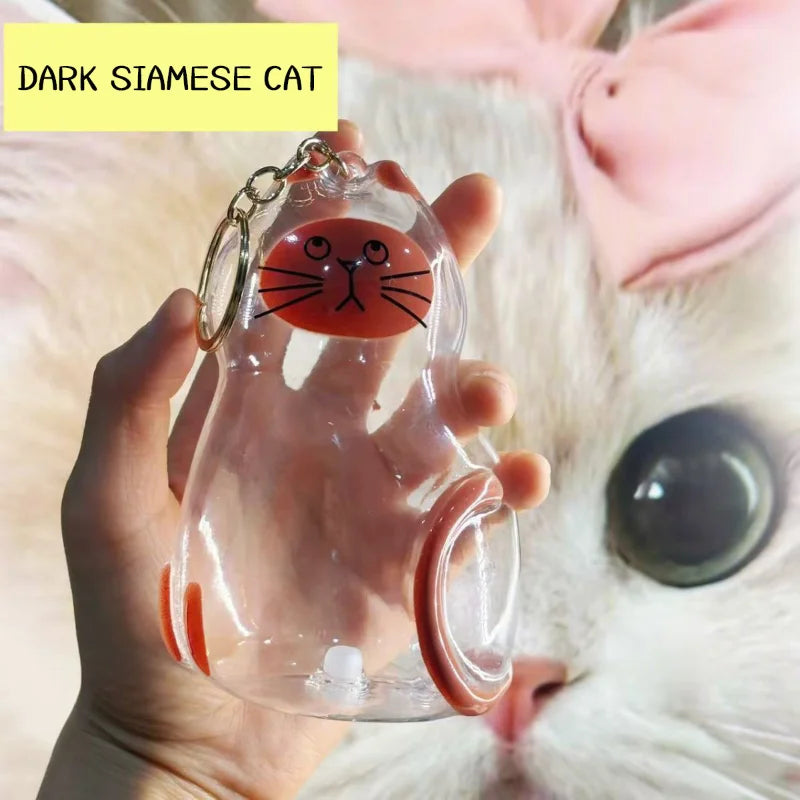 Eine Hand hält ein durchsichtiges Silikon-Katzenhaarkeychain-Set mit einem Design einer dunklen Siamkatze.
