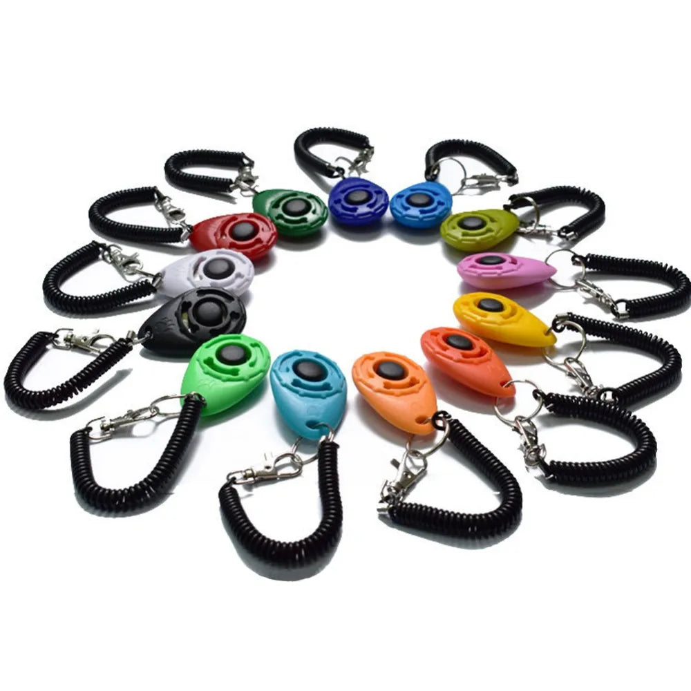 A collection of colorful pet training clickers on black wrist straps arranged in a circle.