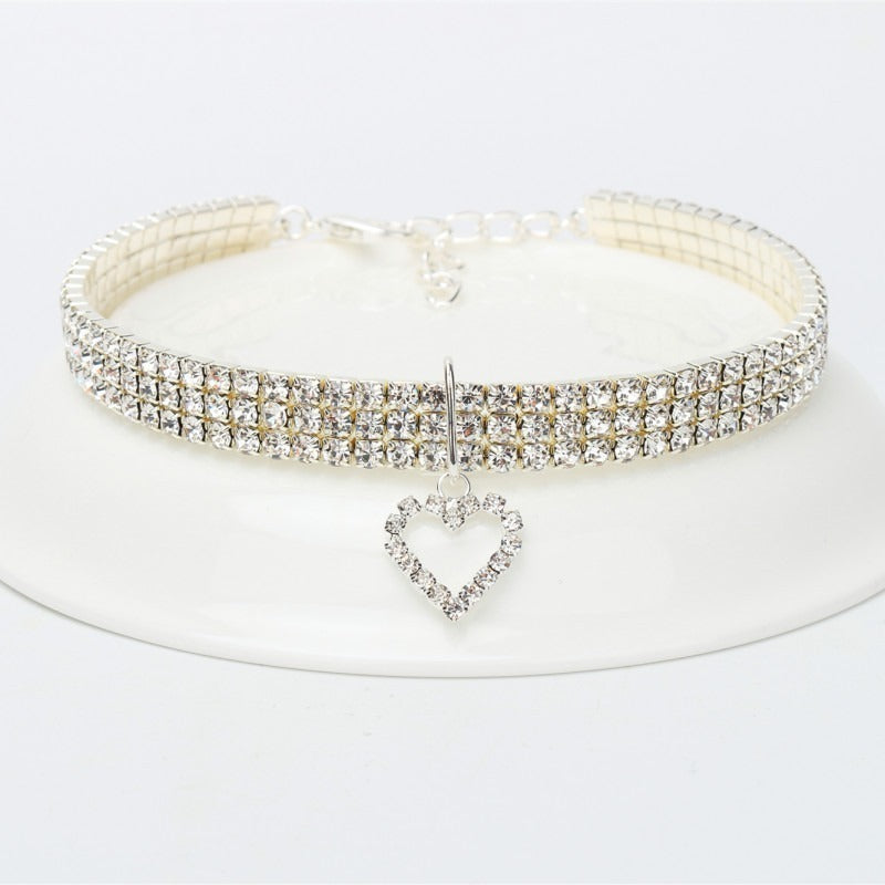 A sparkling rhinestone collar for dogs or cats displayed on a white plate.