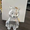 Figurine en verre clair d'un chien assis avec une chaîne dorée pour les poils.