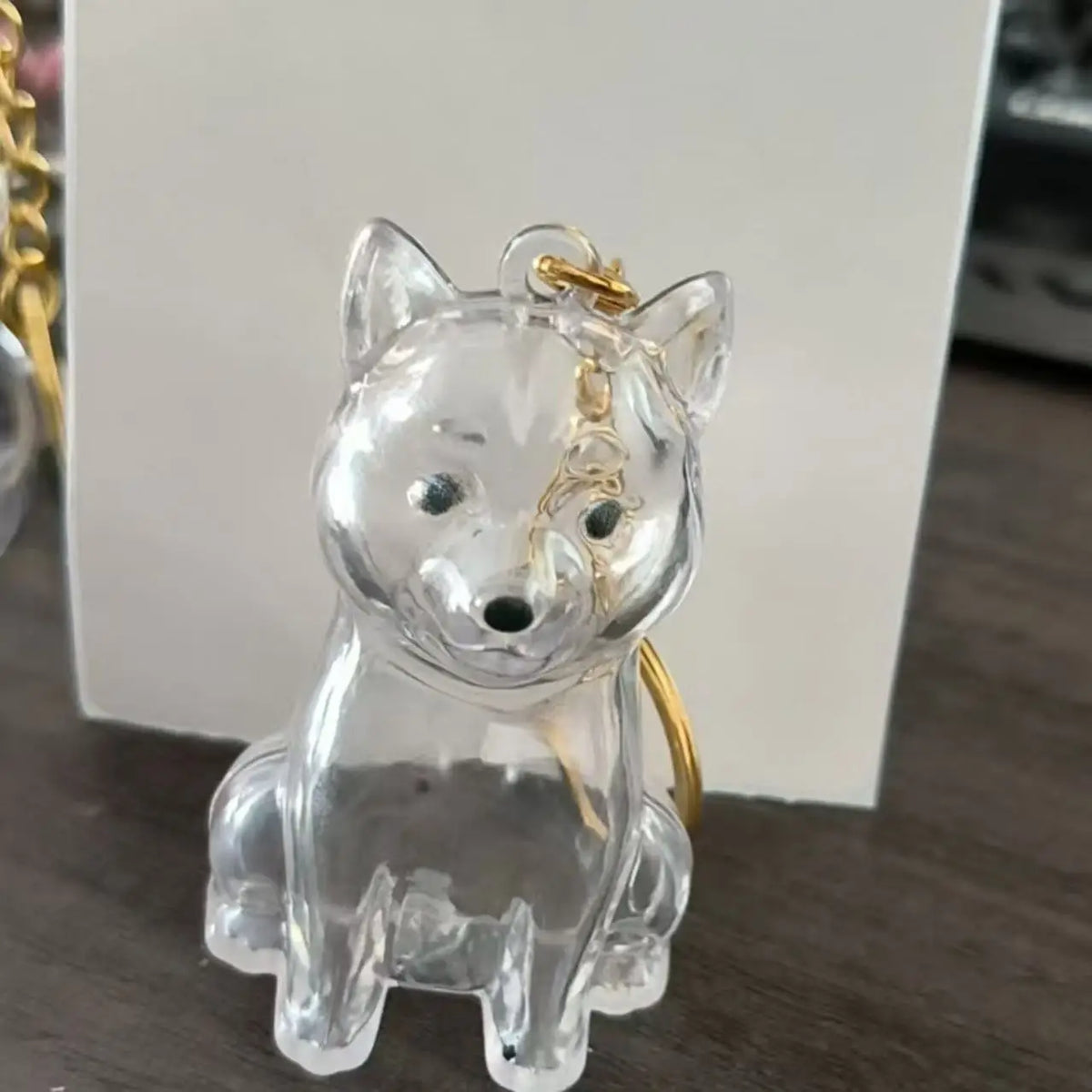 Figurine en verre clair d'un chien assis avec une chaîne dorée pour les poils.