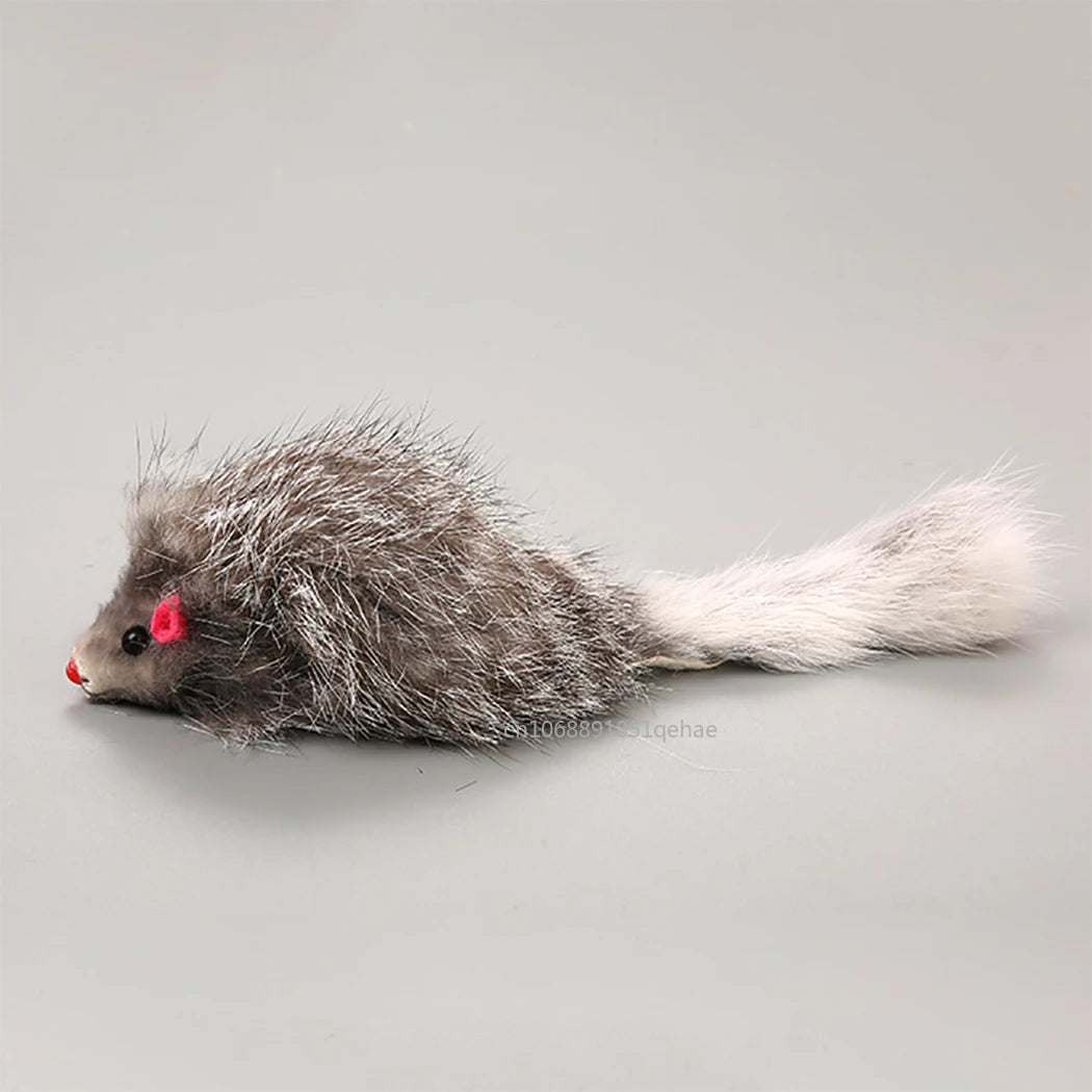 Plüsch-Mauskatze mit grauem Körper und langem weißen Schwanz vor hellem grauem Hintergrund.