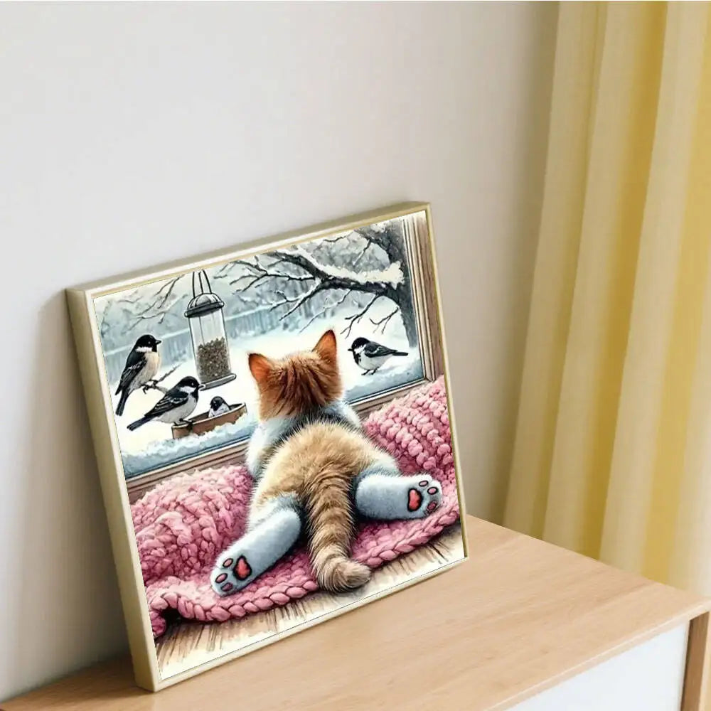 A diamond painting kit featuring a cat resting on pink fabric with birds and branches as the background.